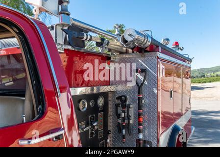 Nahaufnahme des hinteren Feuerwehrautos mit seitlicher Wassersteuerung und rissigen Werkzeugen für jede Art von Rettungseinsatz. Stockfoto