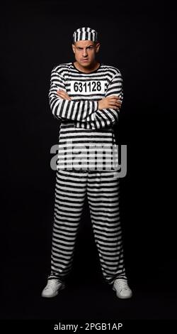 Gefangener in gestreifter Uniform auf schwarzem Hintergrund Stockfoto