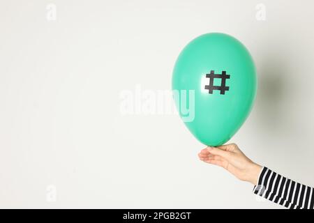 Frau mit grünem Ballon und Papiersymbol auf weißem Hintergrund, Nahaufnahme Stockfoto