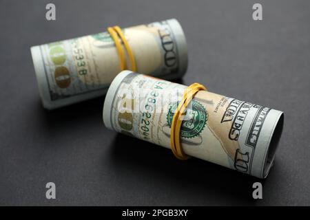 Gerollte Dollarscheine auf schwarzem Hintergrund, Nahaufnahme. Amerikanische Landeswährung Stockfoto