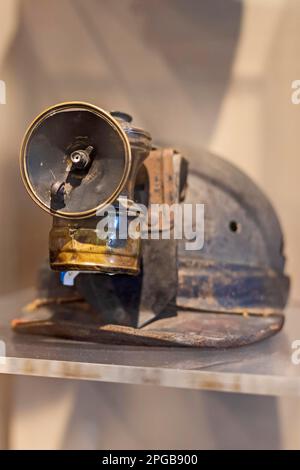 Beckley, West Virginia, Eine Minenlampe aus Hartmetall, die an seinem Helm angebracht ist und im Bergbaumuseum der Beckley Exhibition Coal Mine ausgestellt wird. In der Lampe Stockfoto