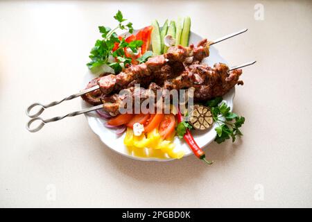 Hausgemachte gegrillte Kebabs aus Schweinefleisch mit Gemüse, serviert auf Schieferteller. Horizontal Stockfoto