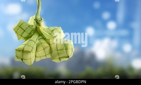 Ketupat (Reisklößchen) ist ein traditionelles Essen Indonesiens während eid al fitr auf verschwommenem Hintergrund Stockfoto