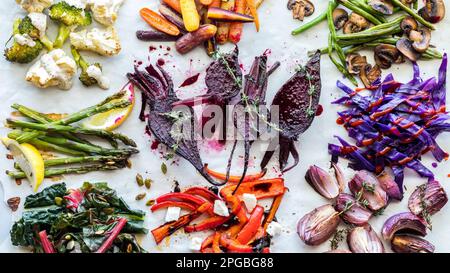 Blick von oben auf verschiedene geröstete und gedämpfte Gemüsesorten mit verschiedenen Belägen. Stockfoto