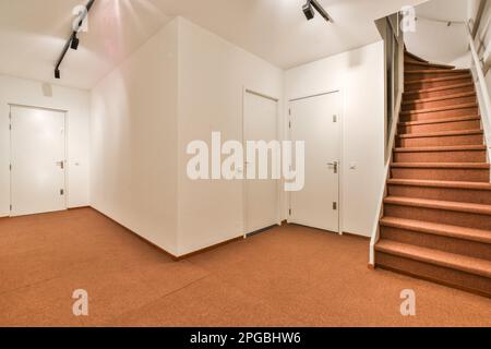 Ein leeres Zimmer mit Treppen und weißen Türen in der Ecke, von unten bis zum zweiten Stock Stockfoto