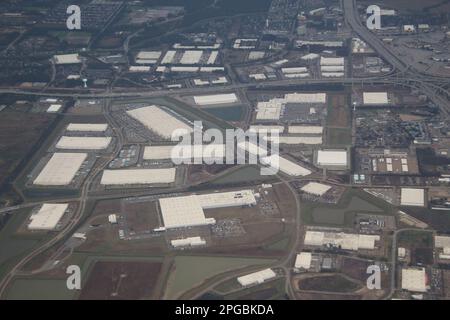 Von oben erstreckt sich der weitläufige industrielle Lagerhauskomplex mit Reihen von Metalldächern und Laderampen so weit das Auge reicht. Stockfoto
