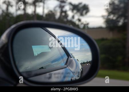 Das Fahrzeug fährt durch einen Rückspiegel Stockfoto