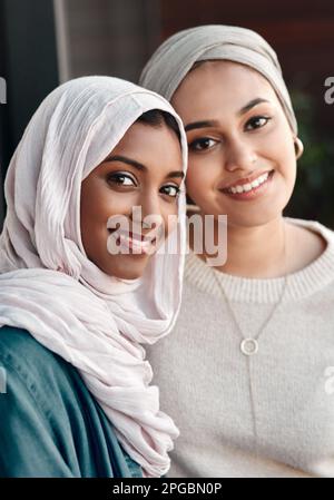 Mein bester Freund bringt Licht in mein Wochenende. Verkürztes Porträt von zwei liebevollen jungen Freundinnen, die in Hijab-Kleidung zusammen in einem Café rumhängen. Stockfoto