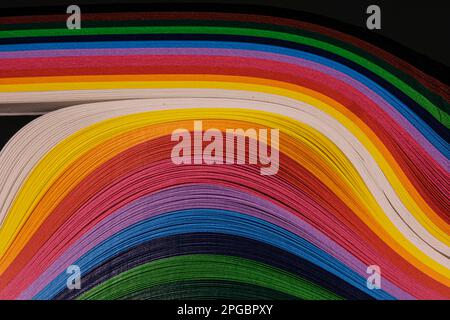 Abstrakte Farbe Welle curl Regenbogen Streifen Papier auf schwarzem Hintergrund Stockfoto