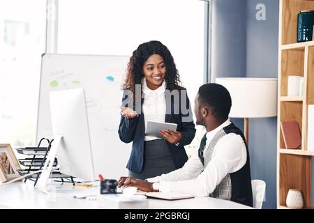 Arbeiten Sie mit Menschen zusammen, die Erfolg schaffen können. Ein junger Geschäftsmann und eine junge Geschäftsfrau, die ein digitales Tablet und einen Computer in einem modernen verwenden Stockfoto