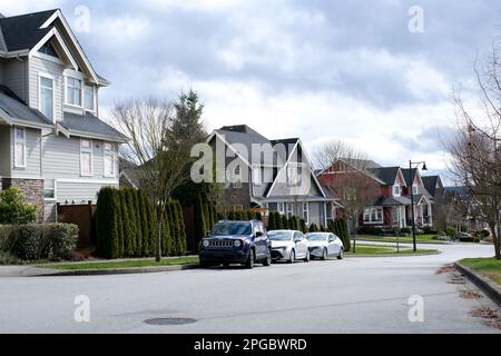 Eine Reihe neuer Häuser in Surrey, British Columbia, Kanada. Vorgarten der Häuser und Straße mit Bäumen und Büschen. Hochwertiges Foto Stockfoto