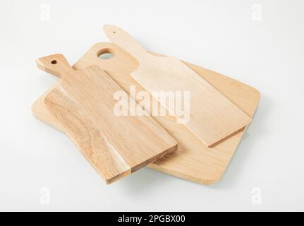 Küchenutensilien aus Holz. Drei Schneidebretter auf hellem Hintergrund. Stockfoto