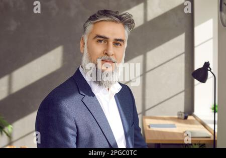 Porträt eines erfolgreichen bärtigen, reifen Geschäftsmannes im Anzug bei der Arbeit im Büro Stockfoto