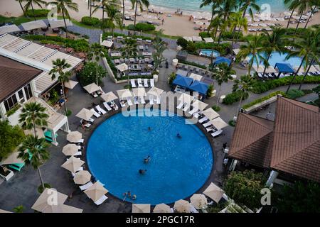 Ein luxuriöser Resort-Swimmingpool in tropischer Umgebung mit wunderschönem Blick auf den Strand und das Meer Stockfoto