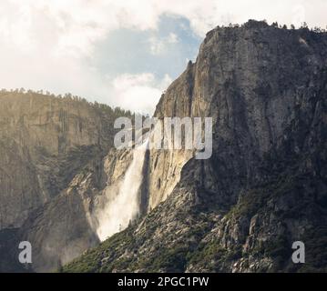 Eine Landschaft mit einem dramatischen Wasserfall, der die Felswand hinunterragt. Stockfoto