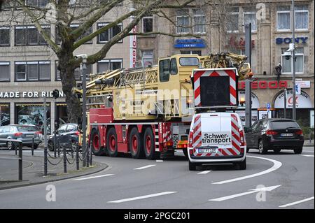Köln, Deutschland. 19. März 2023. Ein schwerer Transport mit Begleitfahrzeug fährt durch die Kölner Innenstadt. Kredit: Horst Galuschka/dpa/Alamy Live News Stockfoto