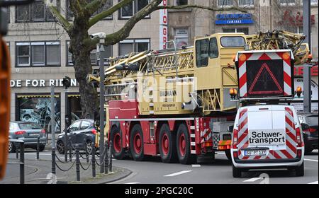Köln, Deutschland. 19. März 2023. Ein schwerer Transport mit Begleitfahrzeug fährt durch die Kölner Innenstadt. Kredit: Horst Galuschka/dpa/Alamy Live News Stockfoto
