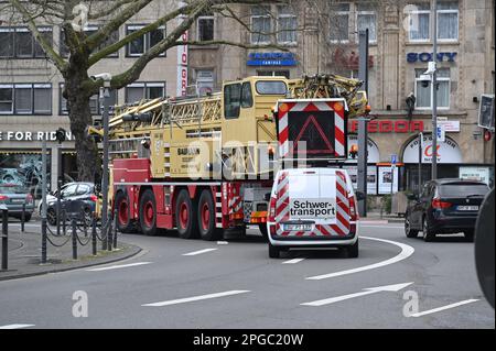 Köln, Deutschland. 19. März 2023. Ein schwerer Transport mit Begleitfahrzeug fährt durch die Kölner Innenstadt. Kredit: Horst Galuschka/dpa/Alamy Live News Stockfoto