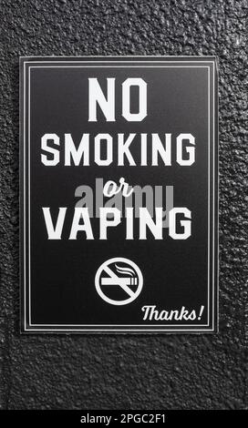 Rauchen verboten. Anti-Dampf- oder elektronisches Rauchzeichen auf schwarzem Hintergrund. Niemand, selektiver Fokus, Straßenfoto Stockfoto