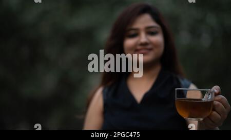 Frauen mit transparentem Glastee, die schwarzen Tee anbieten Stockfoto