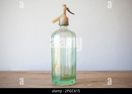 Ein alter Glas-Soda-Siphon. Holzfläche Stockfoto