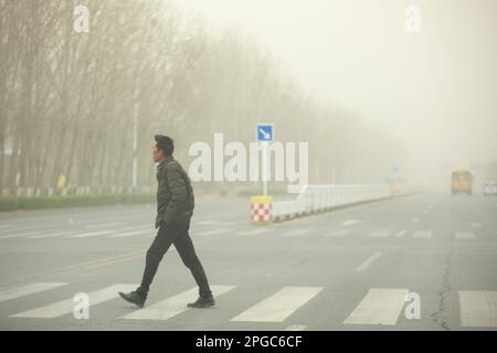 BINZHOU, CHINA - 22. MÄRZ 2023 - Fußgänger reisen während des Sandsturmwetters in Binzhou, Provinz Shandong, China, 22. März 2023. Stockfoto