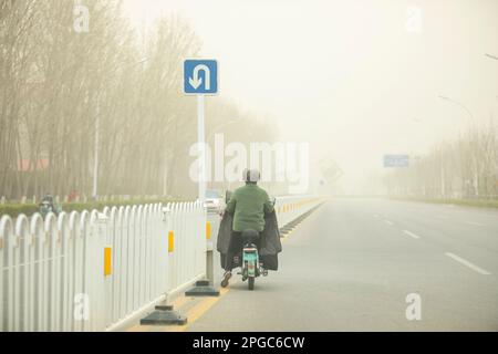 BINZHOU, CHINA - 22. MÄRZ 2023 - Fußgänger reisen während des Sandsturmwetters in Binzhou, Provinz Shandong, China, 22. März 2023. Stockfoto