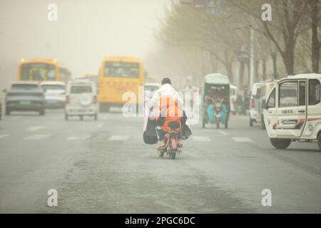 BINZHOU, CHINA - 22. MÄRZ 2023 - Fußgänger reisen während des Sandsturmwetters in Binzhou, Provinz Shandong, China, 22. März 2023. Stockfoto