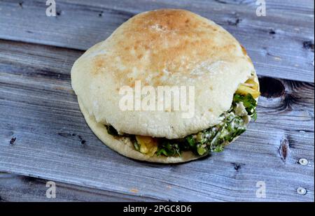 Flat Shami Syrian Bread gefüllt mit pommes Frites und grünem Salat, traditionelle ägyptische frittierte Kartoffeln Finger Sandwich umgeben von kühlen und knusprigen umgeben Stockfoto