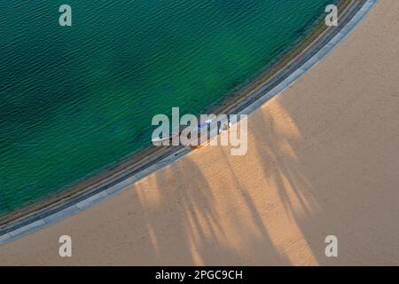 Sandstrand aus der Vogelperspektive, Blick von oben auf einen wunderschönen Sandstrand aus der Vogelperspektive, mit den blauen Wellen, die ins Ufer Rollen, Stockfoto