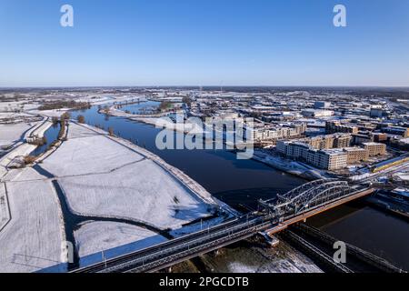 Luftlandschaft nach einem Schneesturm mit Stahlbrücke über den Fluss IJssel und weiße Überschwemmungsebenen der holländischen mittelalterlichen Turmstadt Zutphen Stockfoto