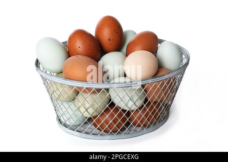 Bunte Eier in einem Korb auf weißem Hintergrund isoliert Stockfoto