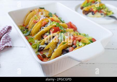 Tacos mit Rinderhack, Kidney Beans, Käse, Tomaten und Salat in einem Auflauf. Im Ofen gebackene Tex-Mex-Mahlzeit Stockfoto