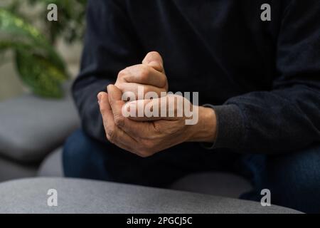 Besorgter religiöser Seniorist betet mit erhobenen Händen zu gott und rührt sich, während er um Hilfe und Inspiration betörend in den Himmel schaut. Stockfoto