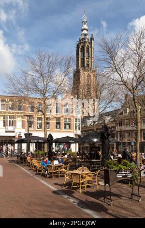 Gemütlicher Platz mit Terrassen und Blick auf den Kirchturm - Turm der Muttergottes im Zentrum der niederländischen Stadt Amersfoort. Stockfoto