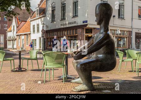 Das Kunstwerk „auf dem Schoß in Amersfoort“ ist ein Sofa in der Form eines schlanken Mannes ohne Hut, der für Mutter spielt. Stockfoto