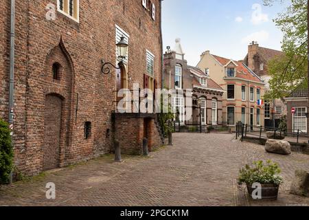Enge Straße mit holländischen Flaggen im alten mittelalterlichen Zentrum der niederländischen Stadt Amersfoort. Stockfoto