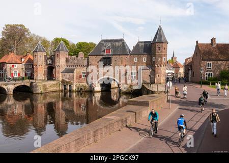 Menschen, die am historischen Land- und Wassertor, dem Koppelpoort in Amersfoort, spazieren und Rad fahren. Stockfoto