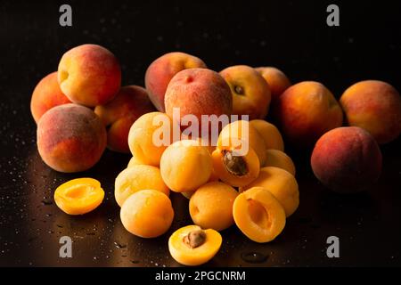 Eine Handvoll reifer Aprikosen auf dunklem Hintergrund. Nützliche Früchte. Ananas-Aprikosen auf schwarzem Hintergrund Stockfoto