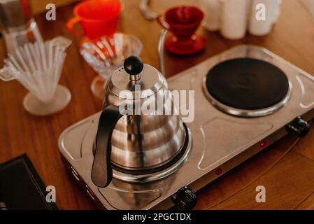 Eine Verkostung einer Moka-Topf-Kaffeemaschine auf einem Holztisch während der Zeremonie Stockfoto