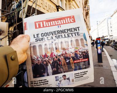 Paris, Frankreich - 20. März 2023: Die französische Regierung auf dem Boden Schlagzeilenartikel auf dem Titelblatt der "l'Humanite"-Zeitung, die in der Stadt gelesen wird Stockfoto