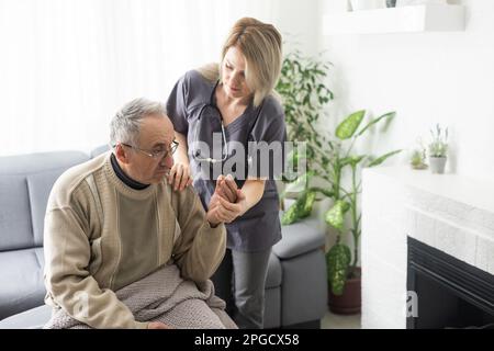 Verärgerter älterer Mann, der unterstützende Rede einer angenehmen Ärztin zuhört, Kopfschuss aus nächster Nähe. Mittelalter Sacharzt alter Patient Stockfoto