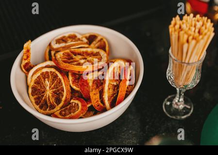 Nahaufnahme einer weißen Schüssel gefüllt mit einer Vielzahl von getrockneten Früchten, einschließlich Aprikosen, Äpfel und Datteln, mit einem Paar Kotelett Stockfoto