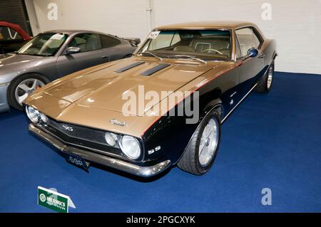 Dreiviertel Vorderansicht eines Gold und Schwarz, 1967 Chevrolet Camaro SS, Teil der London Classic Car Auction 2023 bei Olympia Stockfoto