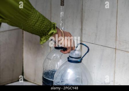 Dhaka, Bangladesch. 22. März 2023. Eine Frau füllt Flaschen mit Wasser aus einem Wasserhahn in Dhaka. Die Leute in Dhaka kochten Wasser auf einem Gasherd, um es zu reinigen. Und da der Preis für Flaschengas gestiegen ist, können sie die Kosten nicht bewältigen, also entscheiden sie sich dafür, das Wasser an Geldautomaten mit einer Prepaid-Karte für tk50 $ und einer Aufstockung von Tk100 $ zu kaufen. (Foto: Sazzad Hossain/SOPA Images/Sipa USA) Guthaben: SIPA USA/Alamy Live News Stockfoto