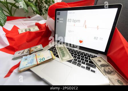 Laptop Gesundheit, Geld und kanada Flagge Stockfoto