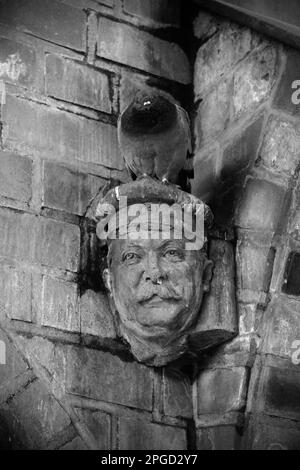 Eine alte graue Wand mit einer dekorativen Skulptur mit einer Feraltaube in Berlin Stockfoto