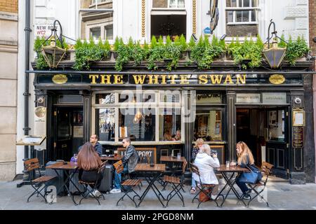 London, Vereinigtes Königreich - 16. April 2022: The White Swan Public House in New Row, Covent Garden, London. Die Kunden sitzen Ende 17. innen und außen, Stockfoto