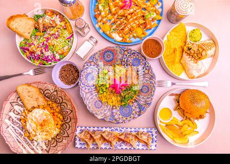 Farbenfrohes Speisenrezept mit Auflauf, Vorspeisen, Gyozas, Burgern mit Kartoffeln und Gewürzen. Stockfoto