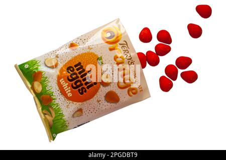 Eine Packung Terrys Chocolate Orange Mini Eggs White wurde geöffnet und der Inhalt wurde verschüttet, isoliert auf weißem Hintergrund - Mini Eggs mit knuspriger Schale Stockfoto